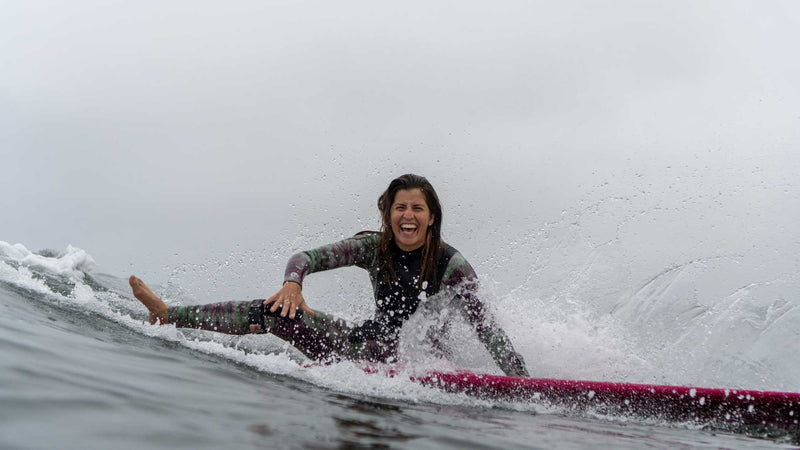 Hakuna Wear Designer and Founder Jessica Boynton surfing smiling in San Diego California