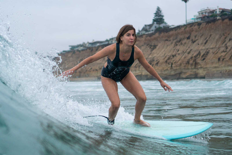 Hakuna Wear Designer and Founder Jessica Boynton surfing on shortboard in San Diego, California